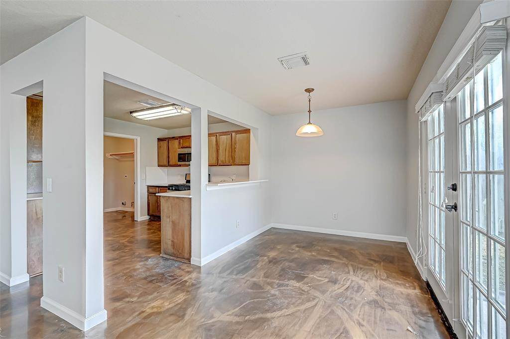 The kitchen is open to the breakfast area, and the double french doors lead out to grassy yard with no neighbors behind.