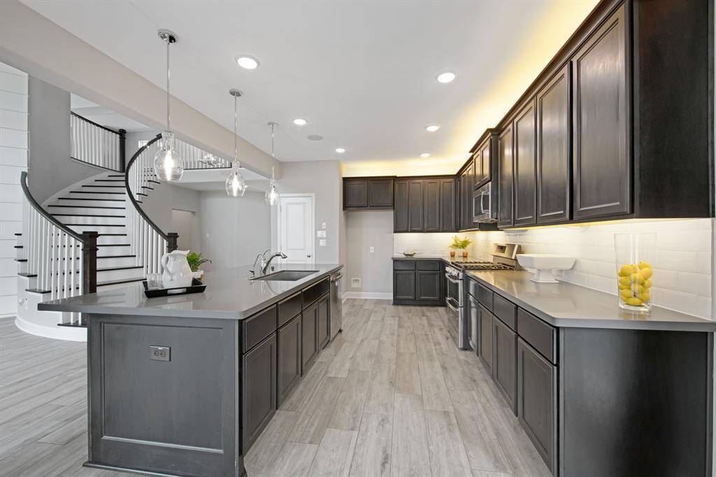 This kitchen has well organized work and storage space with under and above cabinet lighting, Benedettini kitchen cabinets, decorative white ceramic tile backsplash ($465.00), a single stage drinking water system, a 30" gas range with double oven and a microwave with vent to outside.