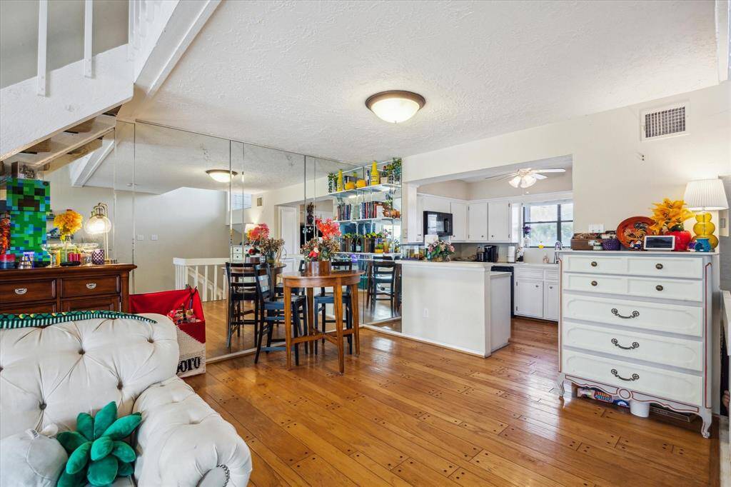 DINING AREA WITH WOOD FLOORS OPEN TO BOTH THE KITCHEN AND LIVING AREA.