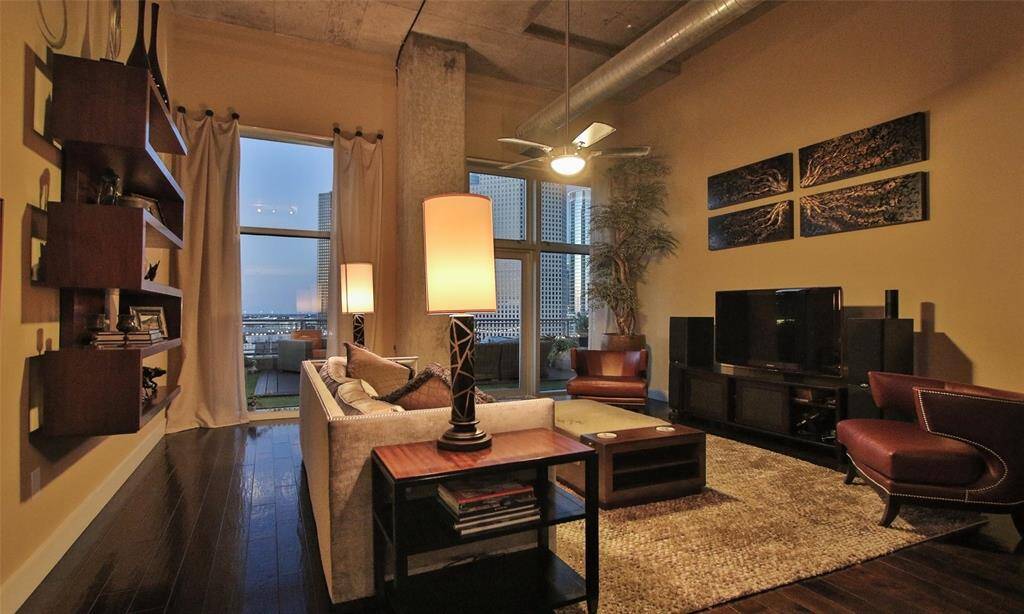 Enjoy views of downtown room your living room.  Benjamin Moore designer paint, wood flooring, and lighting creates a warm and cozy vibe in this lofty room.
