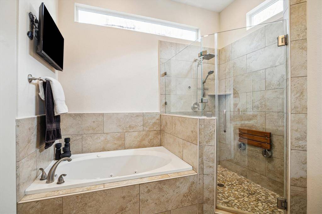 Glass enclosed stand up shower & tub to relax in after a long day at work.