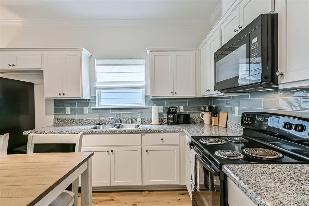Elegant coastal glass backsplash enhances the kitchen's charm.
