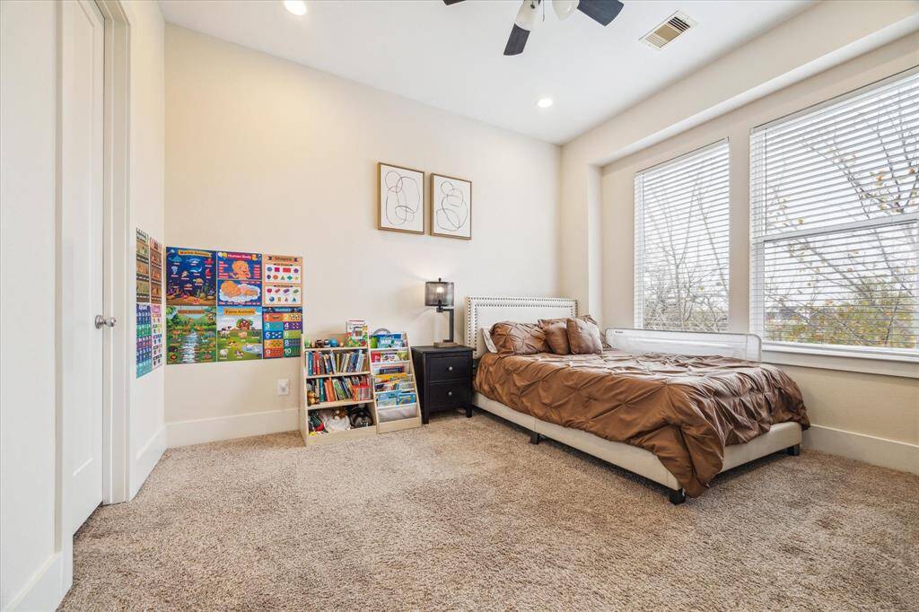 Secondary Bedroom upstairs features two large windows, carpet, recessed lights, walk in closet and an en suite bath.