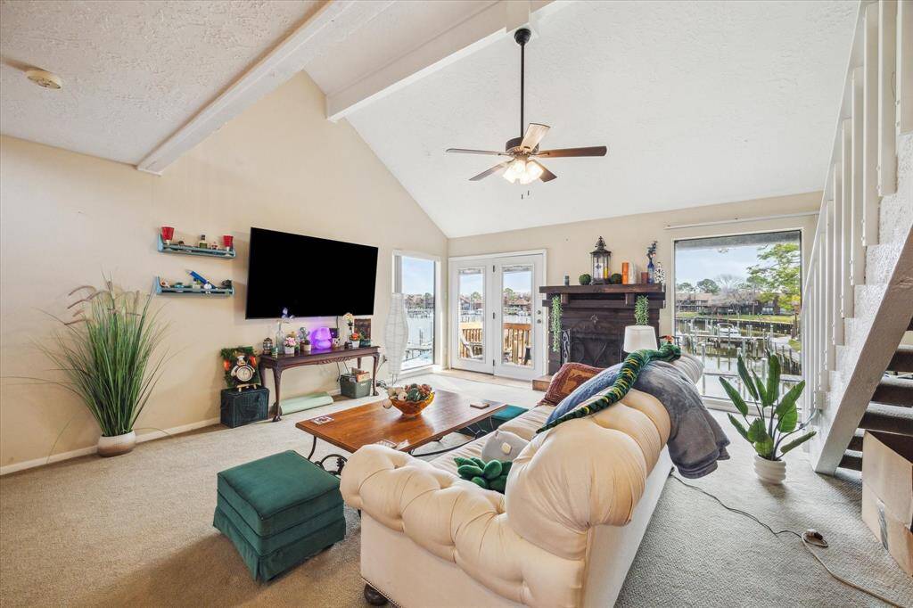 DEN FEATURING A FIREPLACE AND VAULTED CEILINGS.