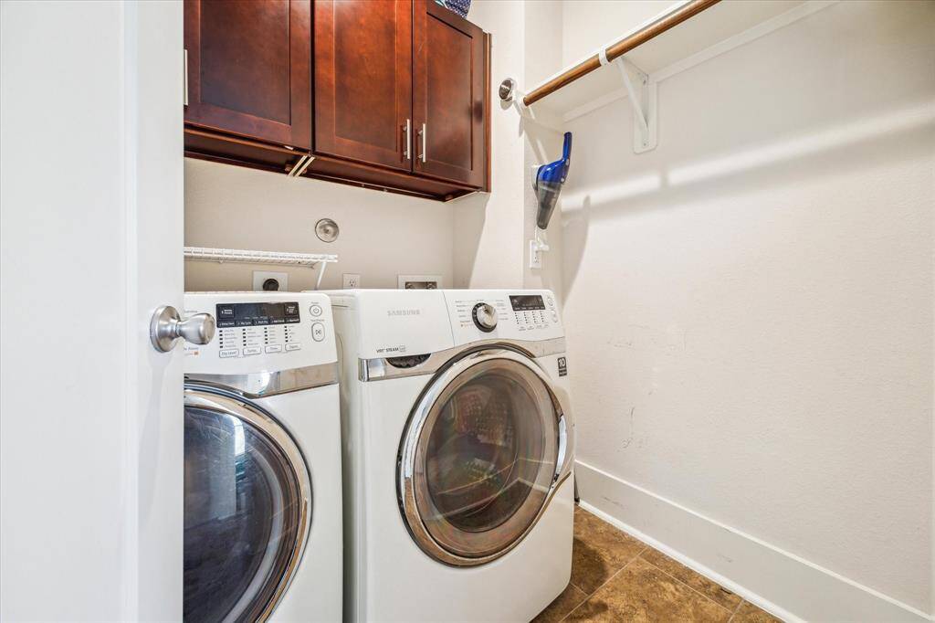 Spacious Utility Room features hanging space and extra cabinets.