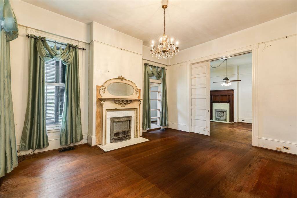 The Parlor on the main level is to the left (West) of the Grand Entry Hall and adjacent to the original music room, now a bedroom. This space features a fireplace with mantel, access to a vintage morning kitchen and is lovely.