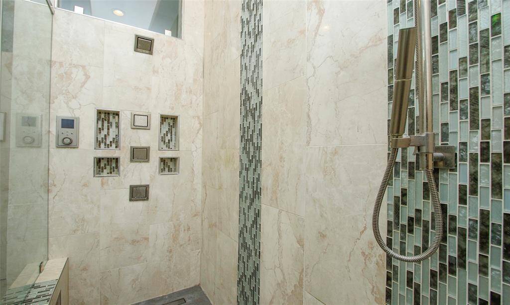 Gorgeously designed with travertine tile and mosaic tile and custom built ins to keep you bath necessities organized.