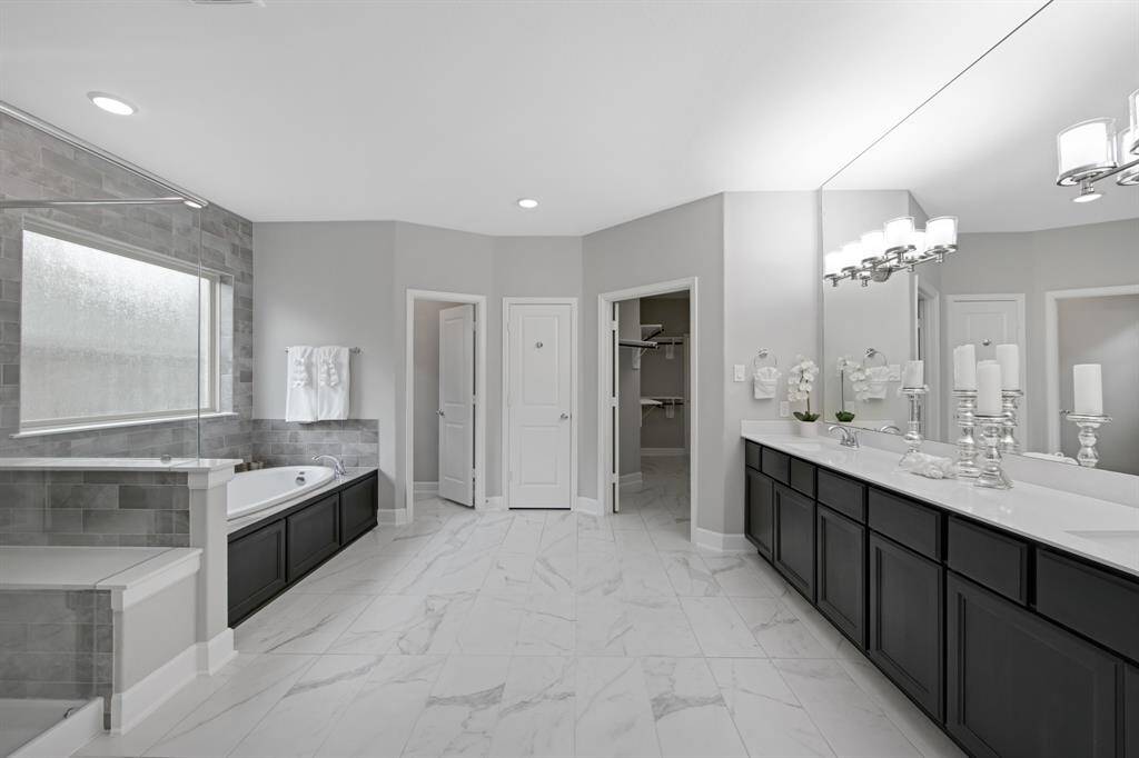 The Primary Bathroom is large with natural light and plenty of storage.The door on the left is to the private toilet, the door in the middle is a linen closet with shelves and the door on the right leads to the BIG closet. The other side of the closet has a door (that can be locked from the inside of the closet) leading to the laundry room.