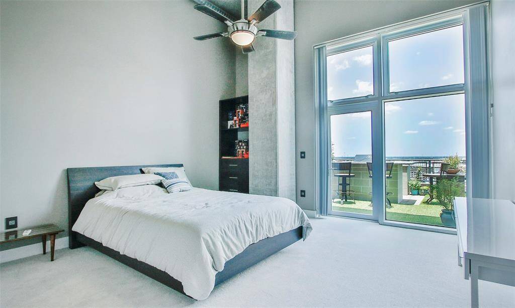 Secondary bedroom with a view! This light and airy bedroom features plush carpet, designer paint, and 15' ceilings.