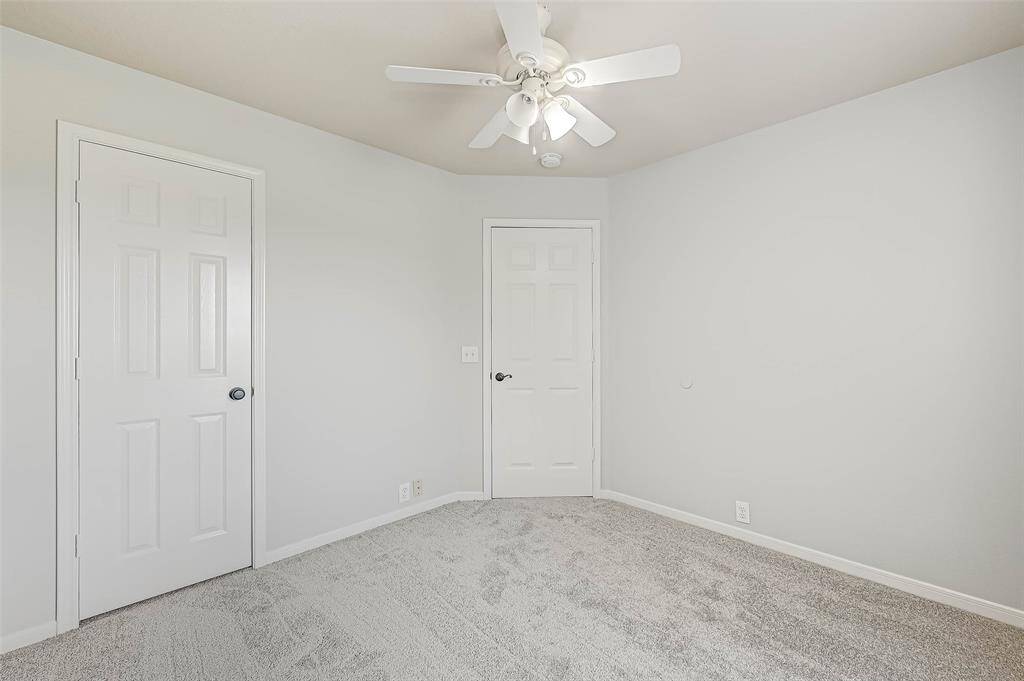 Large secondary bathroom with granite countertop and large framed mirror.