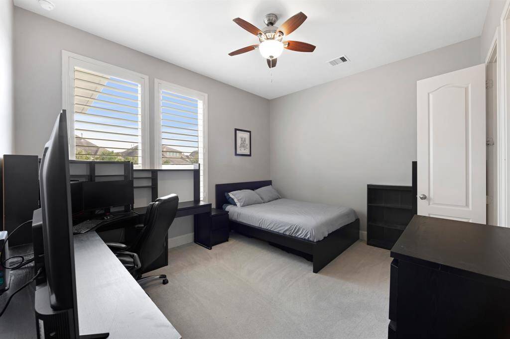 Spacious secondary bedroom on the first floor with plush carpeting.