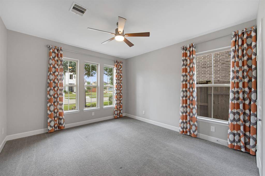 This is the secondary bedroom on the 1st floor with custom designer window treatments and a Kichler Lucian LED 52" ceiling fan.