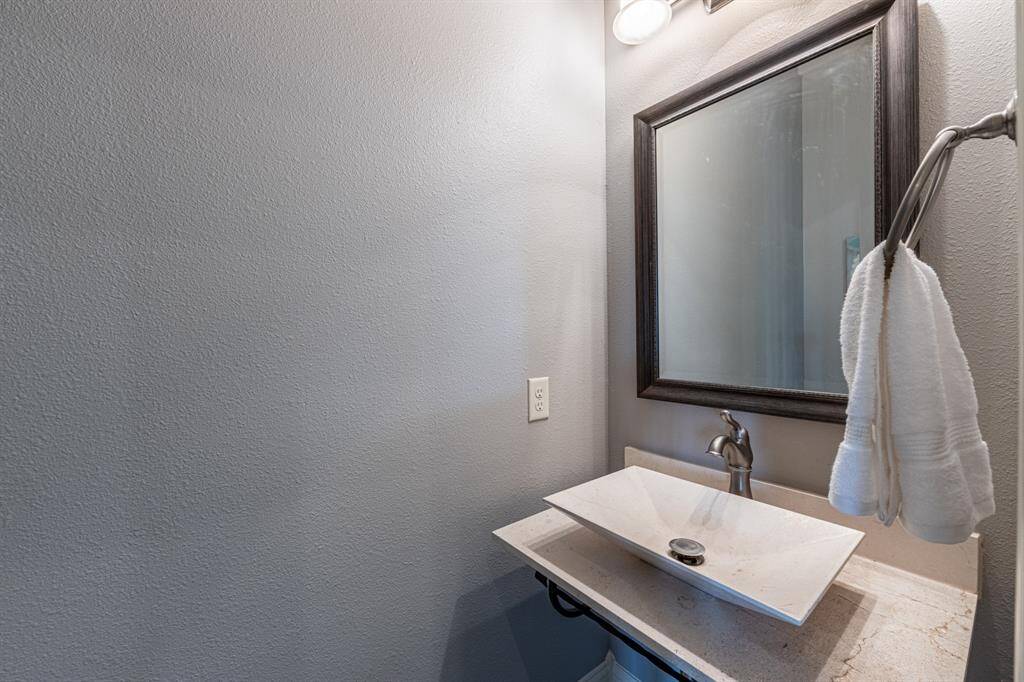 Beautiful powder room with an upgraded sink and framed mirror.