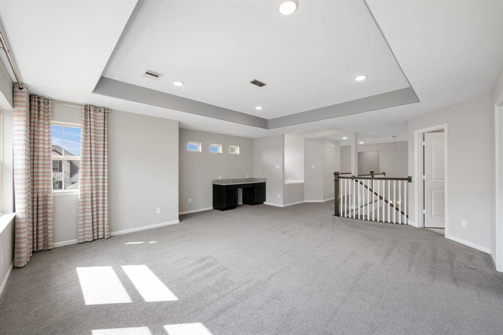 The game room has a tray ceiling with custom paint accent, 4 can lights and it is wired for a pool table fixture. Directly in front of the stair landing area is a decorative nook or a reading nook with a wind