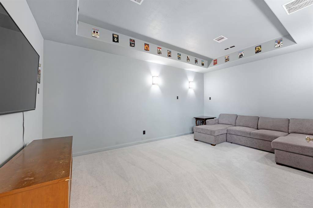 The media room offers an immersive entertainment experience, with a stylish tray ceiling that enhances its cinematic atmosphere. It's fully wired for surround sound, creating the perfect setting for movie nights or gaming sessions with exceptional audio quality.