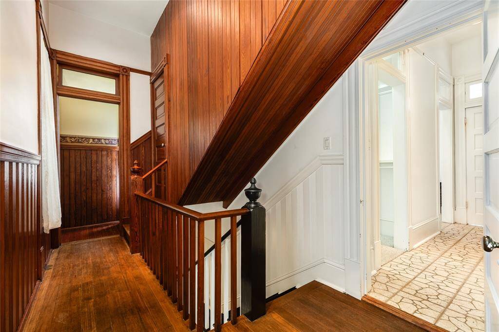 This view shows the laundry room on the left as well as the door to the attic. The stairs go down to the kitchen and the 15th Street entrance. The door on the right goes into the Primary en-suite.