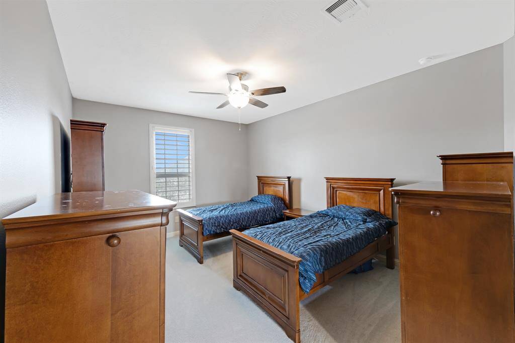 Spacious secondary bedroom with plush carpeting.