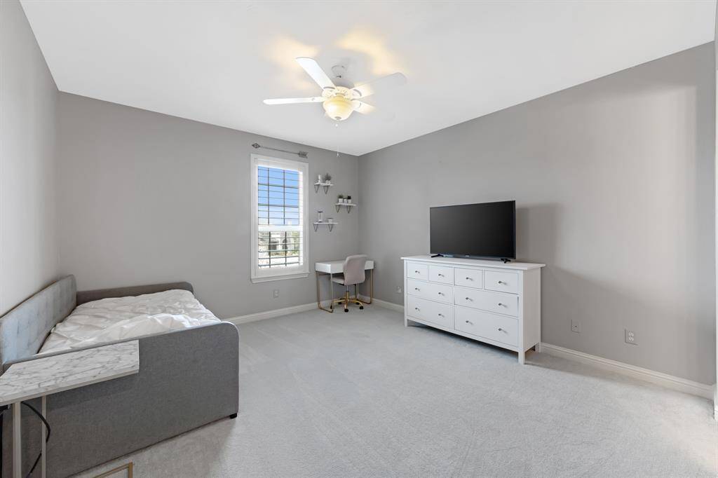 Spacious secondary bedroom with plush carpeting.