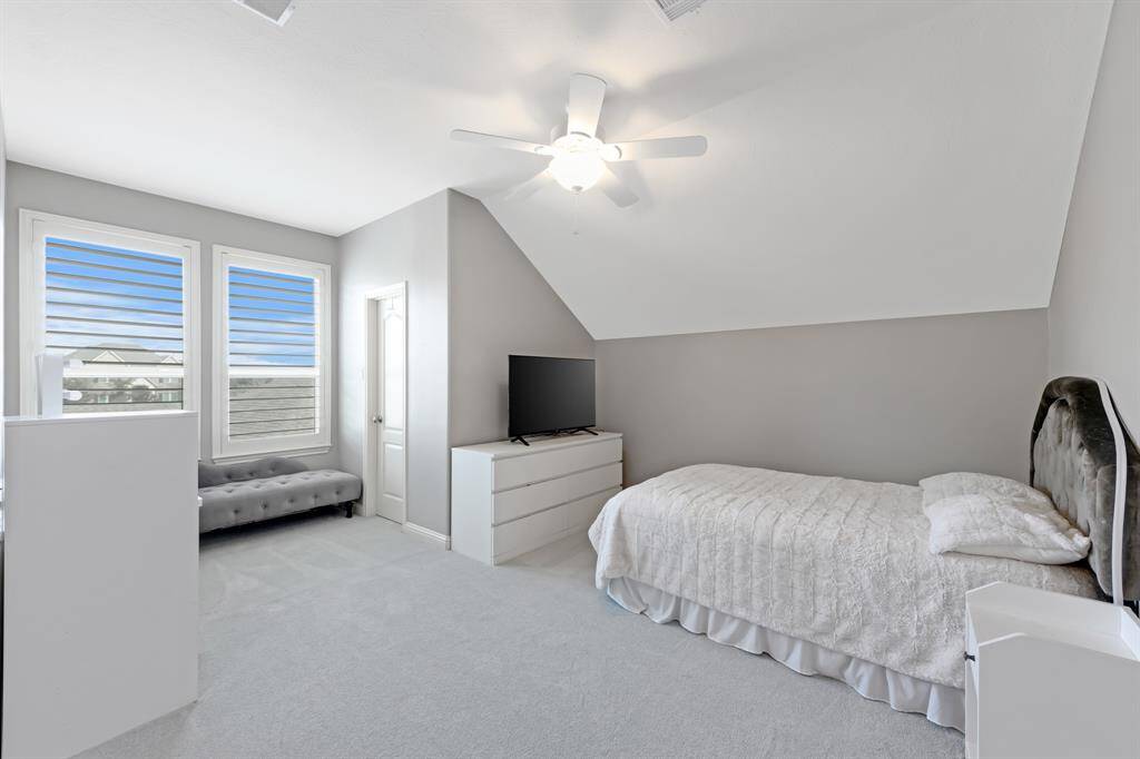 Spacious secondary bedroom with plush carpeting.