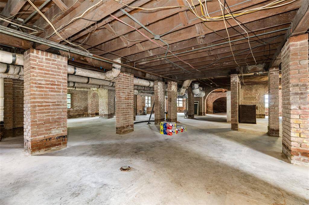 A Galveston basement offering storage and allure. So much more than just a basement, this 124 year old space has had a concrete floor poured and shows off the pride in craftsmanship in the lovely windows, and arches throughout the ground level.