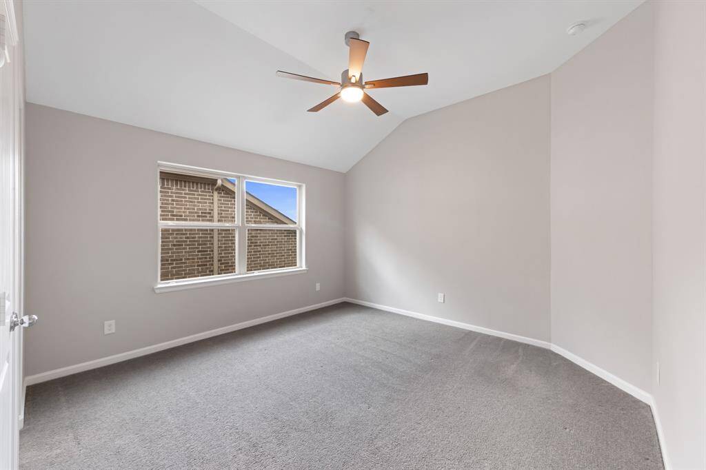 This upstairs secondary bedroom is located toward the middle of the home and has custom designer window treatment as well as a Kichler Lucian LED 52" ceiling fan.