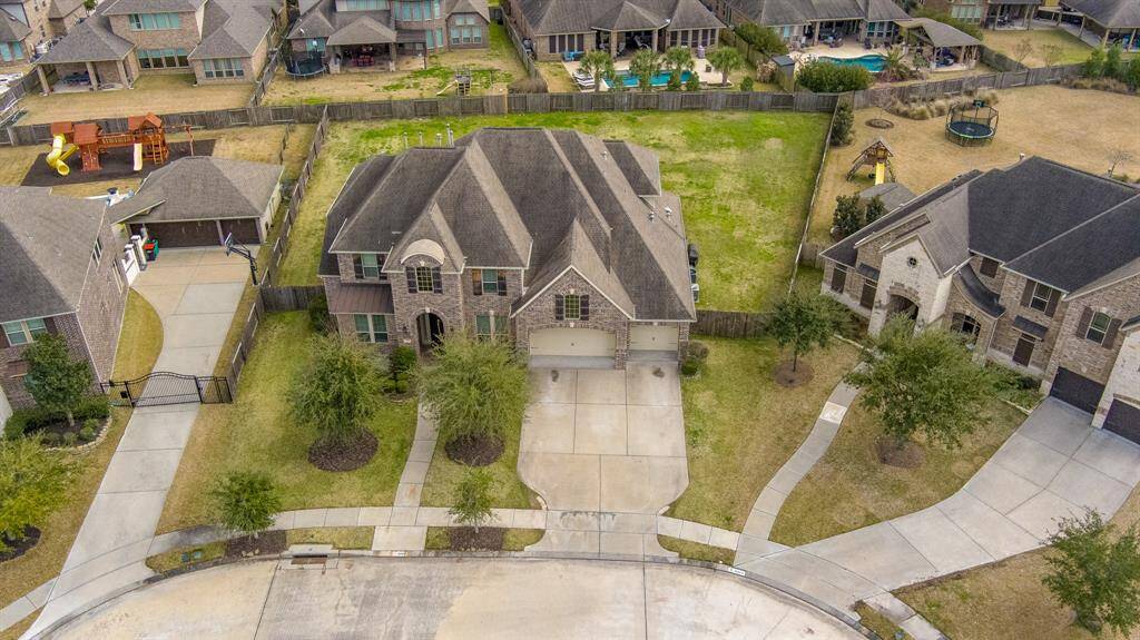An aerial view of the property highlights the impressive scale of this Trendmaker home, showcasing its grand 2-story design and expansive yard. The lush landscaping and generous outdoor space perfectly complement the home’s elegant architecture, offering both privacy and room to entertain.
