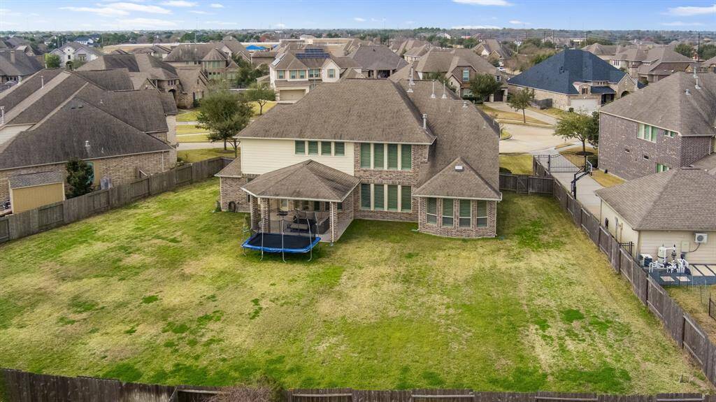 The aerial view of the backyard showcases its expansive layout, highlighting the potential for a variety of outdoor enhancements and offering a stunning perspective of the entire space.