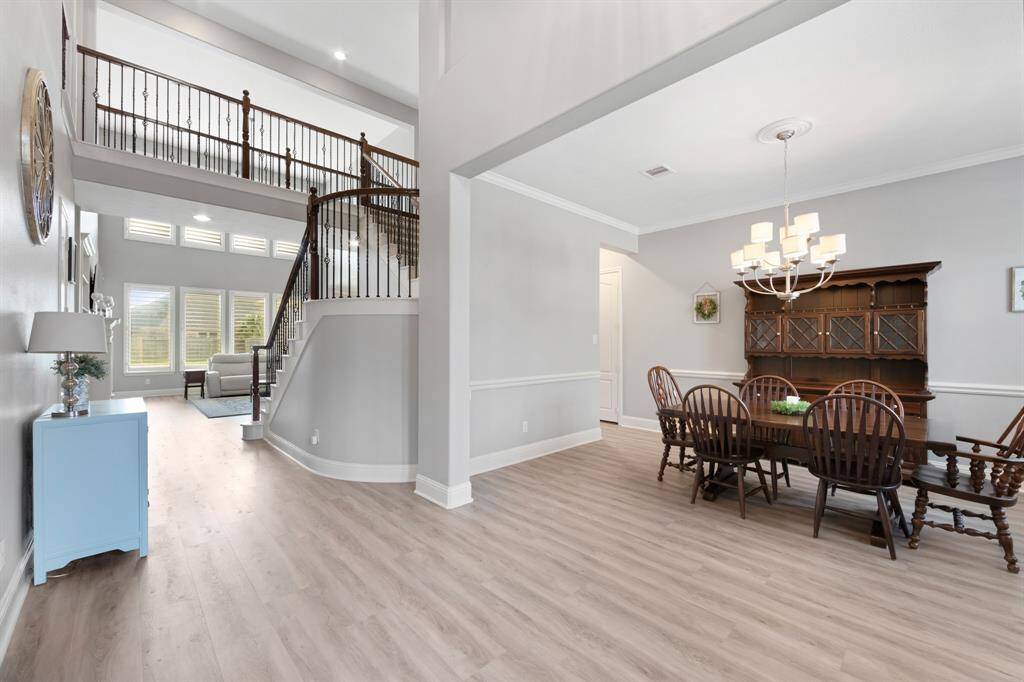The welcoming entryway of this home sets the tone for the rest of the space, featuring elegant 5-inch baseboards and beautiful plantation shutters throughout. As you step inside, the wrought iron spindles on the staircase add a touch of sophistication. The first-floor flooring, which was thoughtfully replaced in 2022, adds a fresh, modern feel, seamlessly blending style and function throughout the living areas.