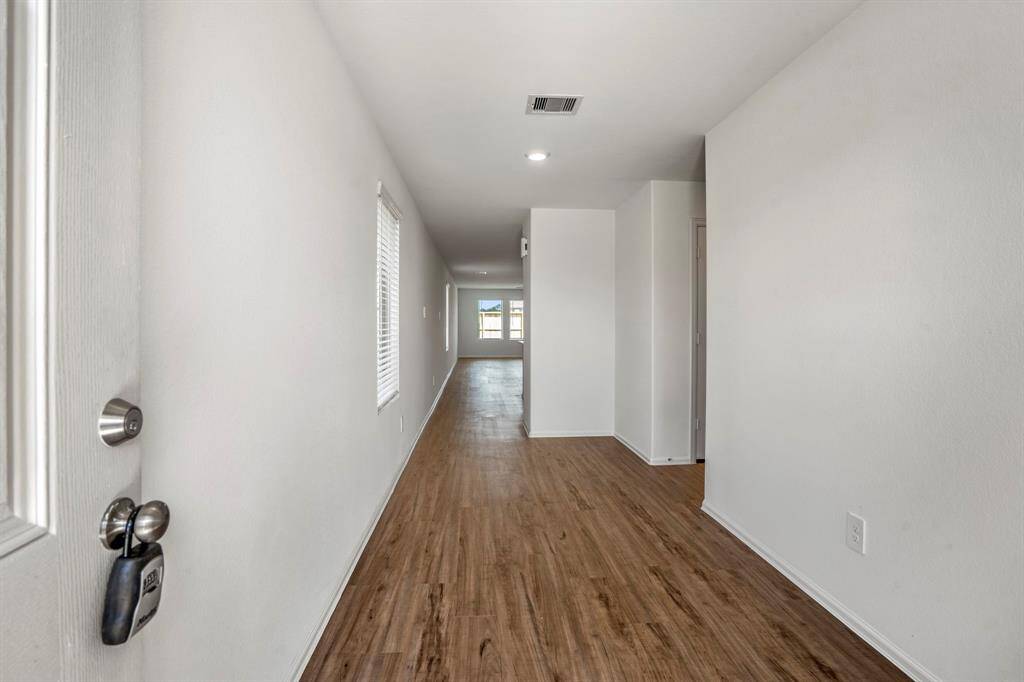 Foyer with wood like flooring that continues throughout.