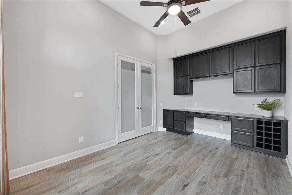 An upgrade of $3,420.00 ~ The wall of custom built-ins desk, file cabinets, storage cabinets and under cabinet lighting (above the desk).