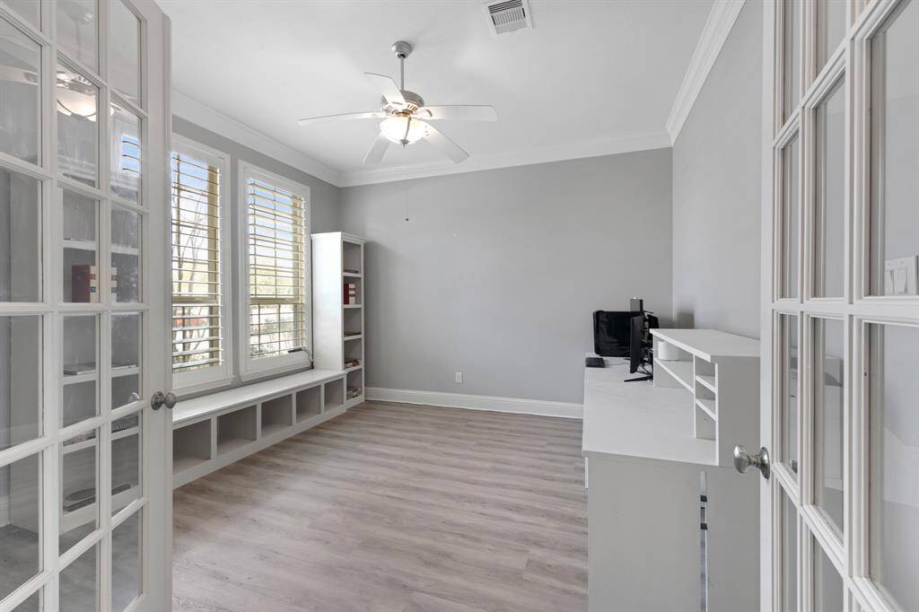 The study offers a serene and professional environment, highlighted by elegant French doors that provide privacy and natural light. Crown molding adds a touch of luxury, while the ceiling fan ensures comfort year-round. This well-appointed space is perfect for working from home or enjoying a quiet retreat.