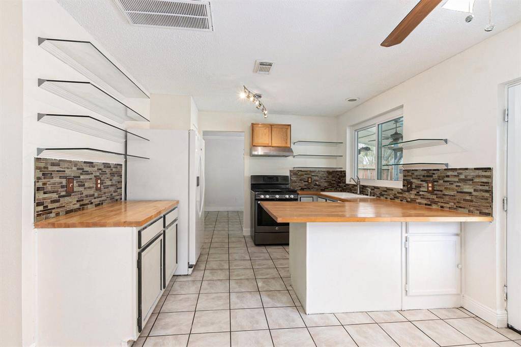 Kitchen features lots of cabinet space, beautiful countertops, and breakfast bar seating.
