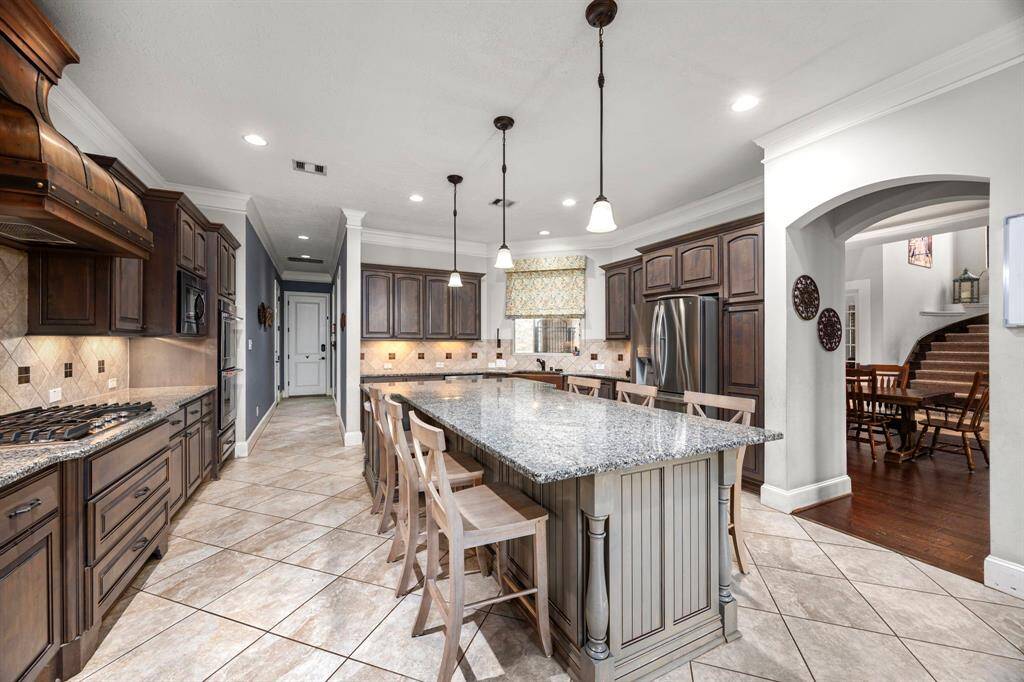 A culinary enthusiast's paradise with a spacious island, gas cooktop, copper range, and walk-in pantry.