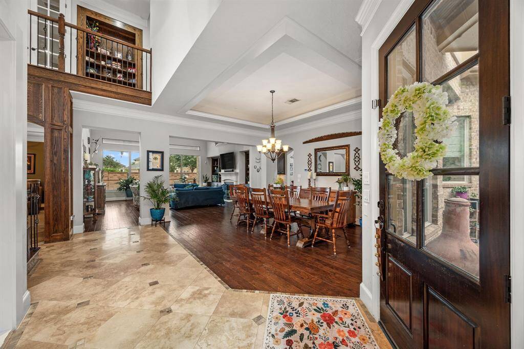 This inviting entryway features a warm wooden door opening into a bright, open-concept living space.