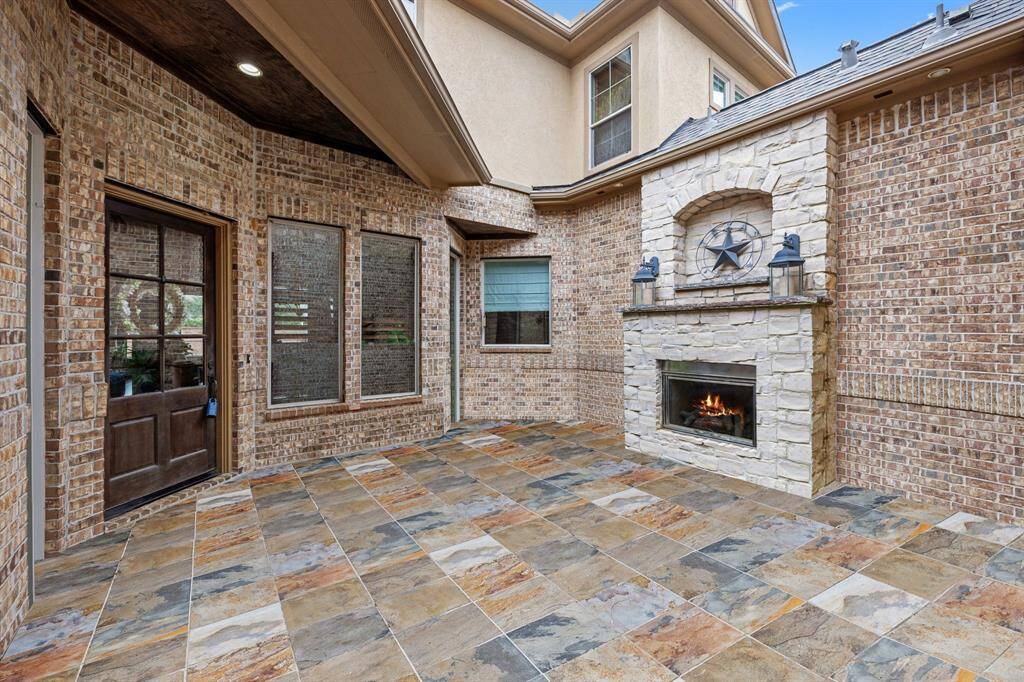 Welcoming front courtyard featuring a cozy fireplace.