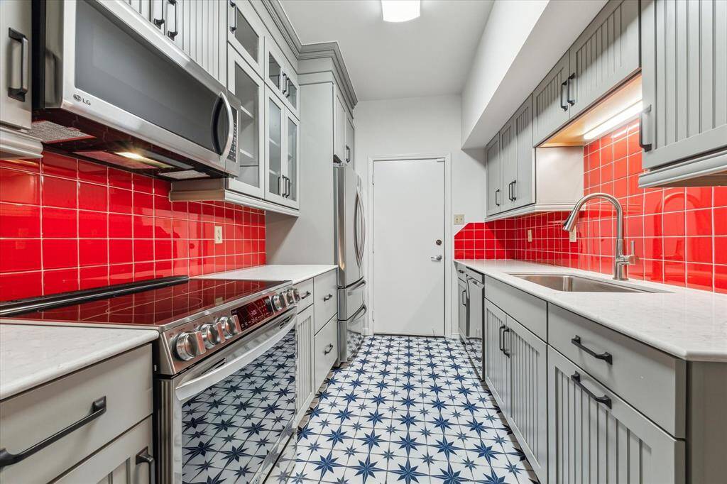 Recently remodeled kitchen with stainless steel appliances, decorative tile selections, undercabinet lighting and custom cabinets. Door pictured center, access to the two-car garage
