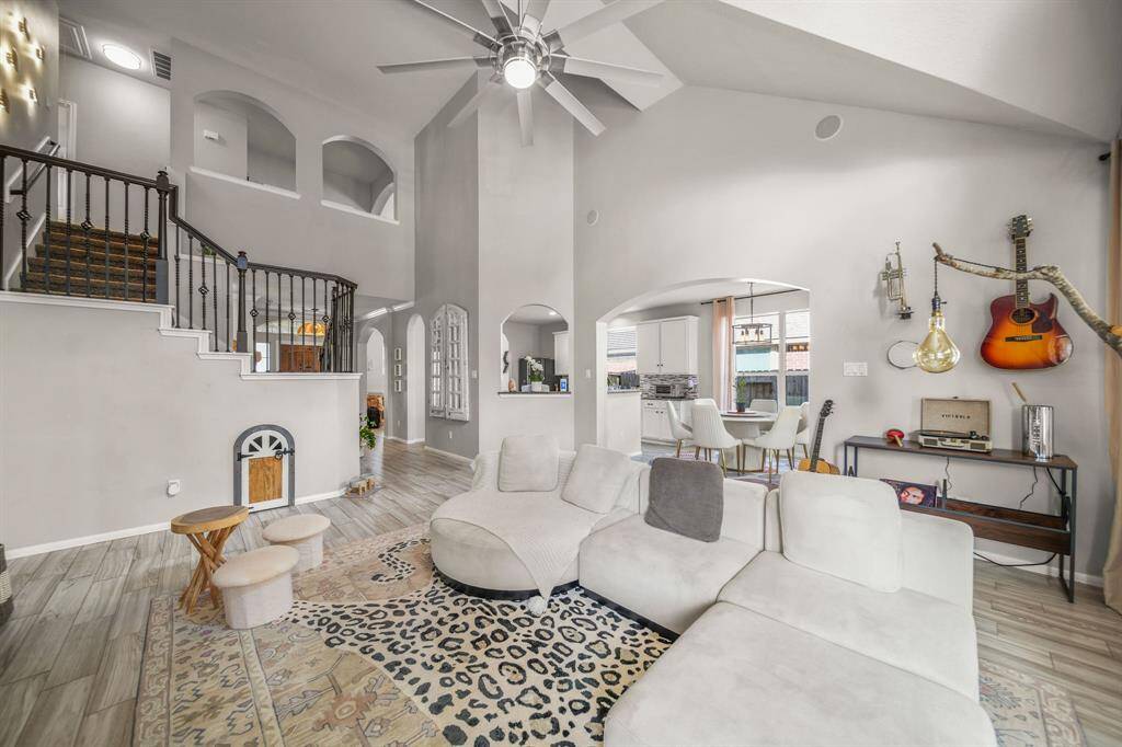 Spacious living room with vaulted ceilings, fireplace, and large windows for bright, open-concept living.
