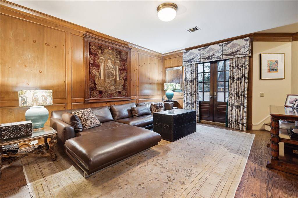 Spacious den on the second floor with wood floor and paneling.