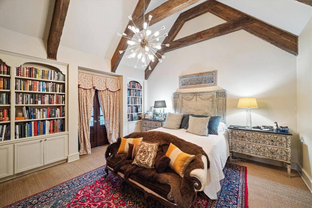 The primary bedroom suite has a beamed cathedral ceiling, French doors leading to the Juliet balcony and lots of book/display shelves.  There are also two luxurious baths with closets galore.