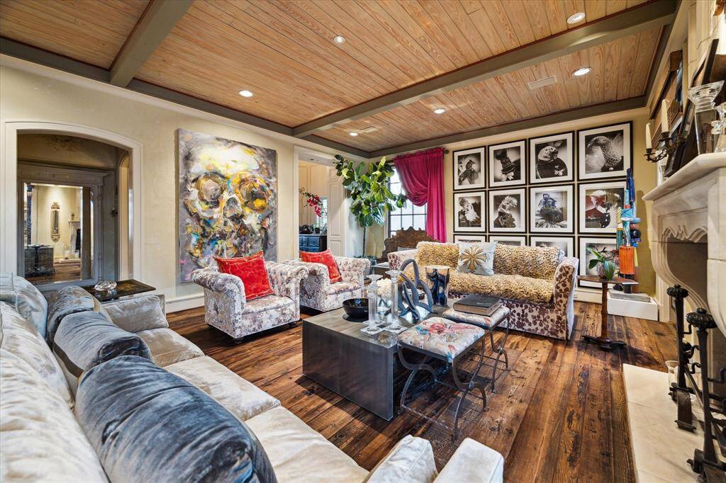 Living Room features art lighting, custom fireplace and alcove giving access to powder room and elevator.