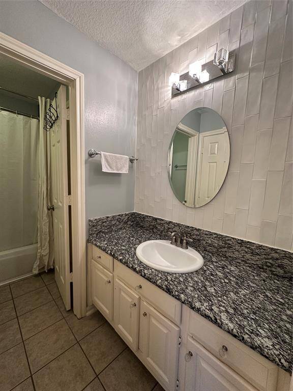 Upstairs full bathroom with granite countertops and designer looks backsplash on wall behind mirror.