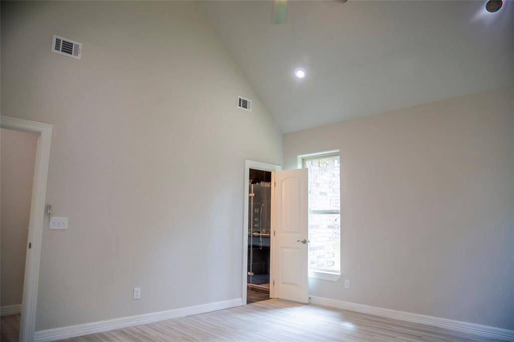 One side of the Primary bedroom with a vaulted ceiling.