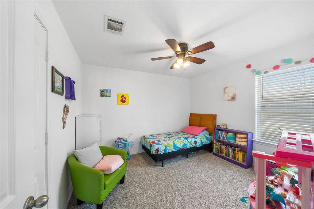 Secondary bedroom with large window, lush carpet, sizable closet and ceiling fan.