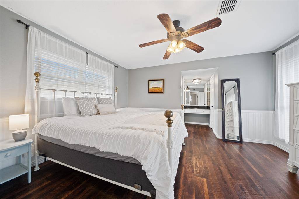 The primary bedroom offers tons of natural lighting, lots of space, and beautiful wood floors.