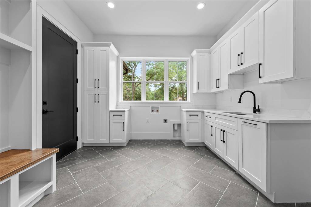 Laundry room off the garage with full size sink, cabinets/drawers and back pack drop zone.