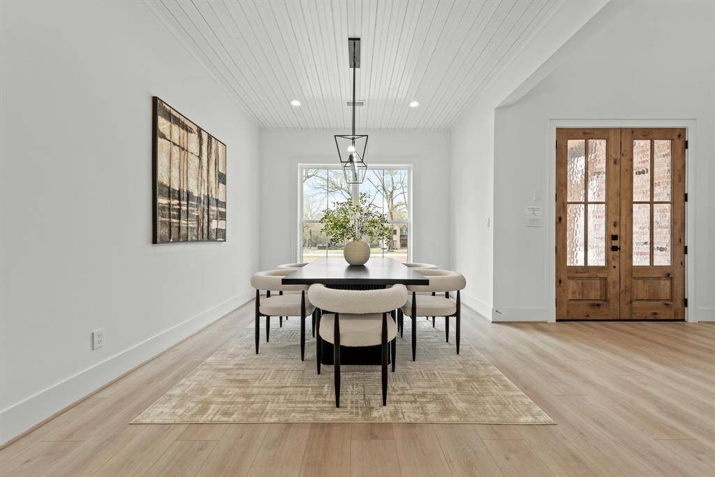 Two story double door entry to home. Dining room with bead board ceiling detail.
