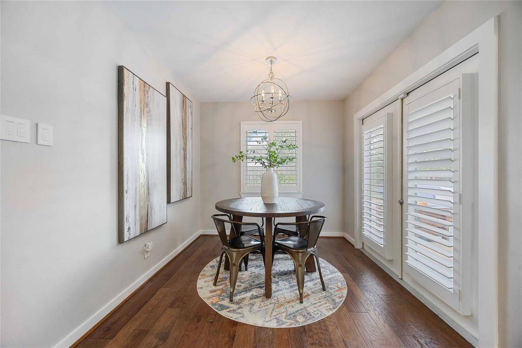 A charming breakfast area rests under a modern light fixture. Lots of natural light fills the space.