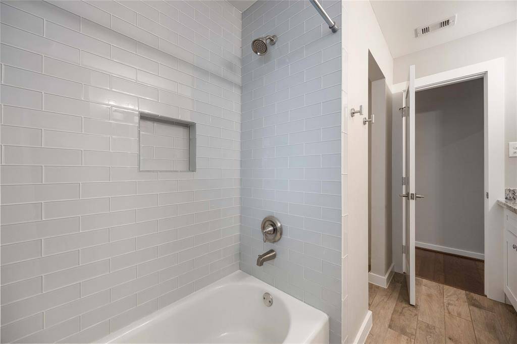 The hall bath features a tub and shower combination.
