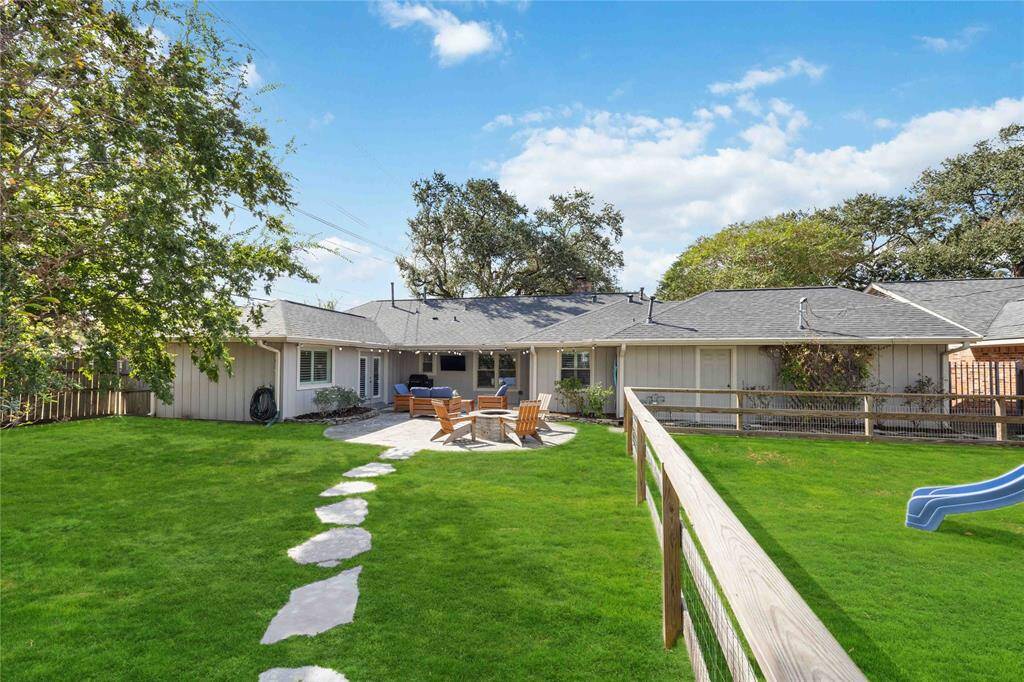 A meticulous lawn is easy to maintain with the wifi-controlled, built-in sprinkler system. A separate area on the right is fenced in and features artificial turf that will stand the test of hours of play time and running around.
