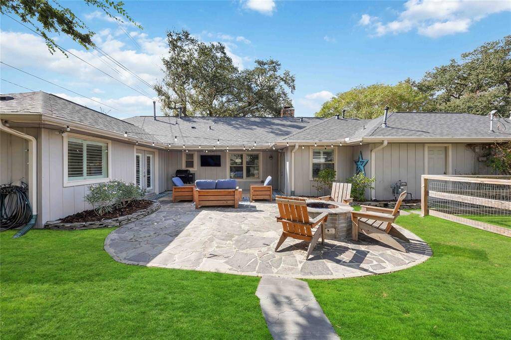 A centrally located flagstone patio boasts plenty of space for outdoor relaxation, including a designated area for a fire pit.